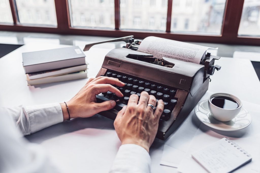 Young writer typing on a retro typewriter