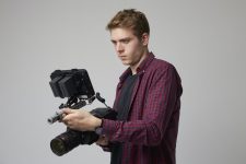 studio-portrait-of-male-videographer-with-film-camera.jpg